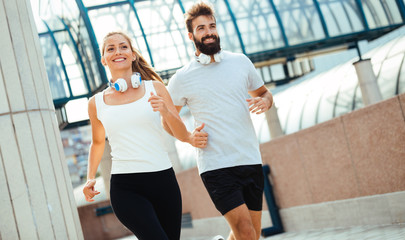 Fototapeta na wymiar Young fitness couple running in urban area