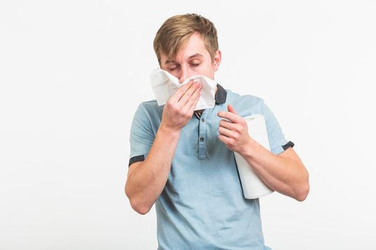 Young man has a runny nose on white background