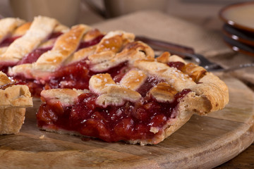 Closeup of a slice of cherry pie on a wooden platter
