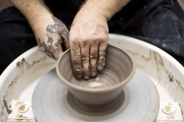 Artist makes clay pottery on a spin wheel