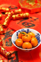 Chinese new year oranges in bowl and fake firecrackers on spring festival  couplets that says happiness and spring is coming