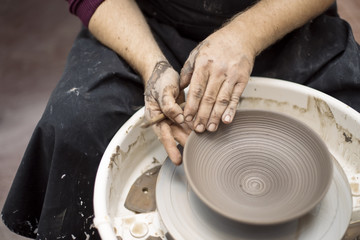 Artist makes clay pottery on a spin wheel