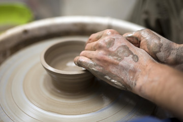 Artist makes clay pottery on a spin wheel