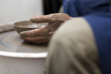 Artist makes clay pottery on a spin wheel