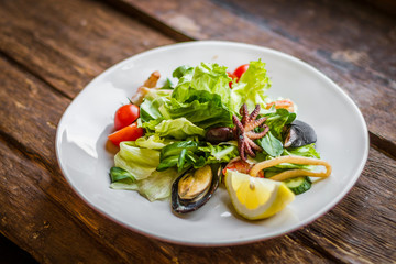 Tasty salad with seafood on a white plate