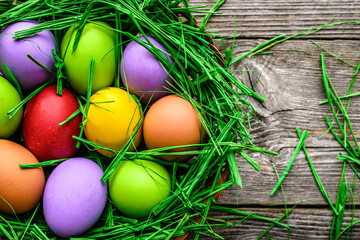 Basket with easter eggs, colorful festive decoration on wooden background
