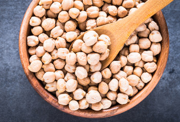 Chickpea in bowl top view on dark rustic background. Dry chickpea bowl.