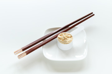 Protein powder in scoop on small plate with chopsticks