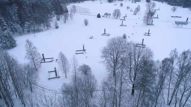 Winter snow covered forest aerial drone video pine tree white woods Belarus fly high Khatyn memorial