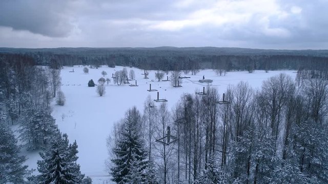 Winter snow covered forest aerial drone video pine tree white woods Belarus fly high Khatyn memorial