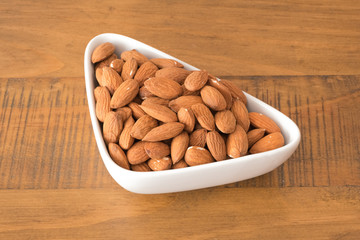 Bowl of Dried Walnuts on Wooden oak table.