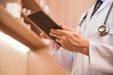 Doctor hands using and pointing on digital tablet.