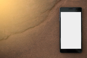 Smartphone with blank screen, isolated on brown sandstone background.