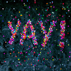 Interjection 'yay!' made of colorful confetti on black textured background.