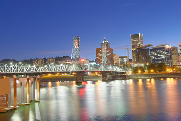 Plakat PORTLAND, OREGON - AUGUST 21, 2017: City night skyline along the river. Portland attracts 5 million people annually