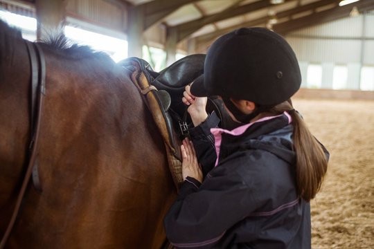 Female rider securing saddle