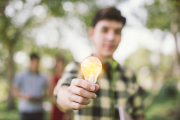 man teen student holding to the illuminated bulb .Light Bulb Think Ideas Create .focus Light Bulb