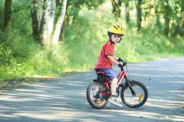 Portrait of a cute boy on bicycle, wearing safety helmet