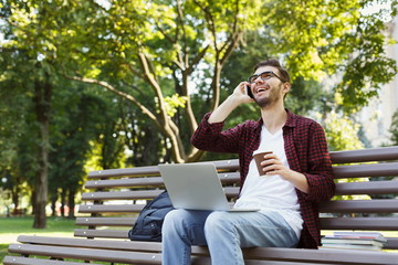 Smiling man talking on mobile phone outdoors