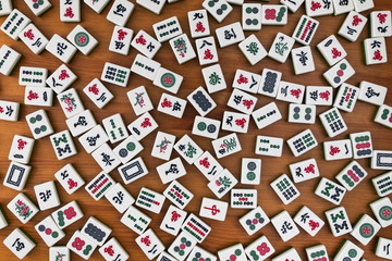 White-green tiles for mahjong on a brown wooden background. No empty place.