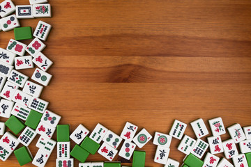 White-green tiles for mahjong on a brown wooden background. Empty place in the upper right corner