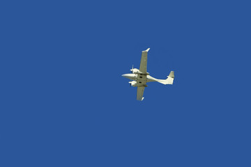 a small white plane flying in the sky