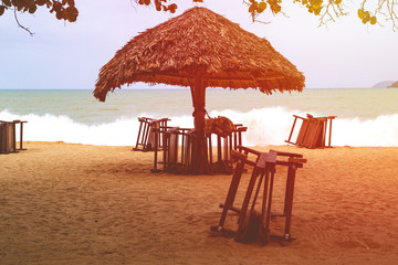 lonely sandy beach with beach chairs and umbrellas near the sea with big waves