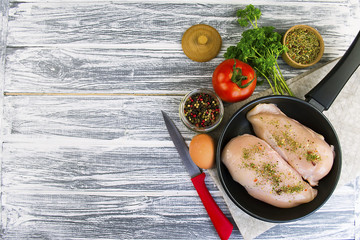raw chicken fillet with spices in a frying pan