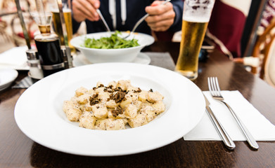Potato gnocchi, Italian potato dumplings with truffle mushrooms and cheese sauce on a plate in a restaurant.