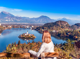 Travel Slovenia, Europe. Young woman looking at Bled Lake and Alps Mountain. Bled Lake is amazing touristic attractions.