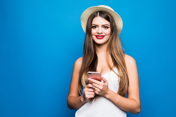 Pretty woman in straw hat using smartphone over colorful blue background