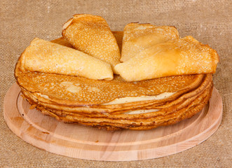 Fried pancakes lie on a wooden cutting board. The concept of baking. Horizontal image.