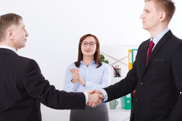 Successful business partnership concept with businessmans handshake. Happy businesswoman applause at office background. Team work businessmen handshaking after profitable deal. Selective focus.