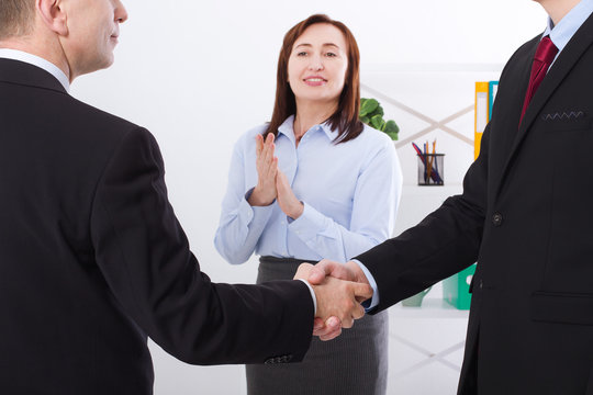 Successful business partnership concept with businessmans handshake. Happy businesswoman applause at office background. Team work businessmen handshaking after profitable deal. Selective focus. Banner