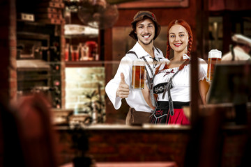 Fototapeta premium young two people in bavarian clothes and small business of bar . 