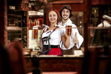 young two people in bavarian clothes and small business of bar . 