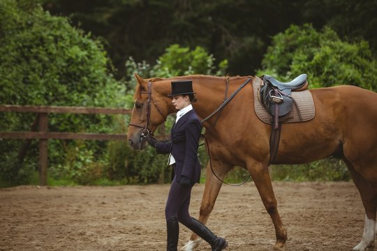 Female jockey leading her horse 
