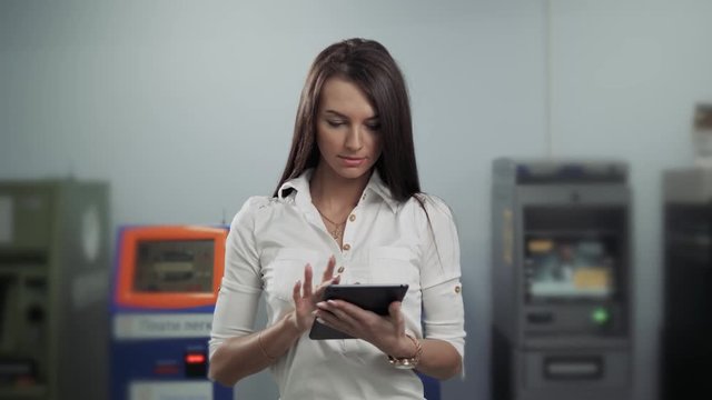 Businesswoman use digital tablet on ATM background, bank work, business woman withdrawal
