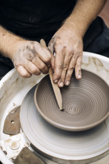 Artist makes clay pottery on a spin wheel