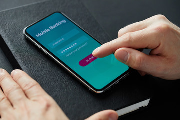 Close up of male hand signs up for banking with their mobile phone