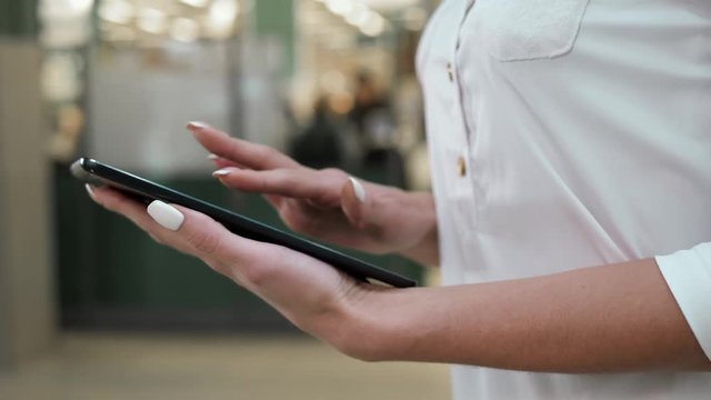 Modern businesswoman. Beautiful young woman holding digital tablet and looking at camera with smile while standing at the grocery shop store