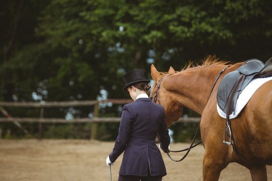 Female jockey leading her horse 