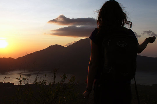 Silhouette of a girl at sunrise on the volcano