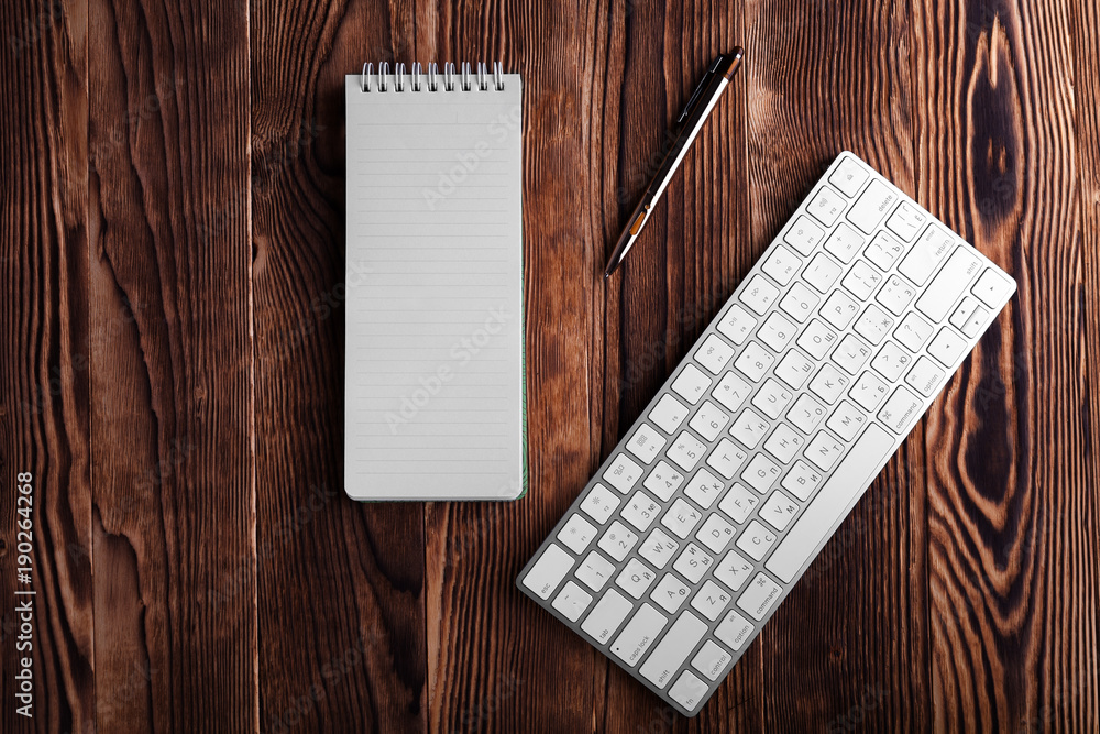 Poster notepad and computer keypad isolated on the wooden desktop