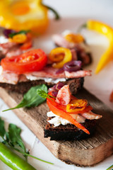 Selection of tasty Bruschetta: tomato and pepper grill, soft cheese, meat, Italian herbs, whole wheat bread.