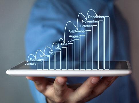 Businessman holding business growth graph.