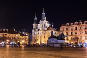 Obraz premium A night view of the beautiful St. Nicholas Church located in the historic Old Town Square in the city of Prague, Czech Republic