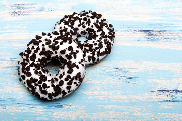 Traditional donuts on blue wooden background. Tasty doughnuts with icing, copy space