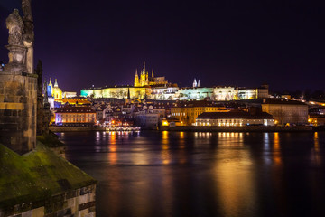 Fototapeta na wymiar Night view of Prague in color lights: ancient historic buildings and St. Vitus Cathedral, Czech Republic