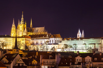Naklejka premium Night view of Prague in color lights: ancient historic buildings and St. Vitus Cathedral, Czech Republic